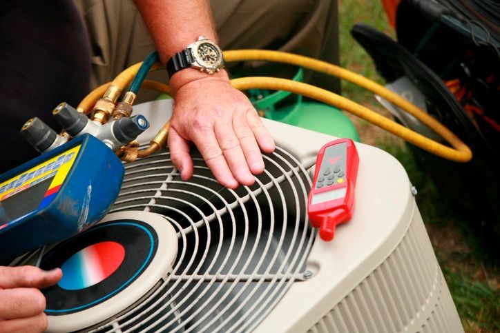 Technician repairing an outdoor air conditioning condenser