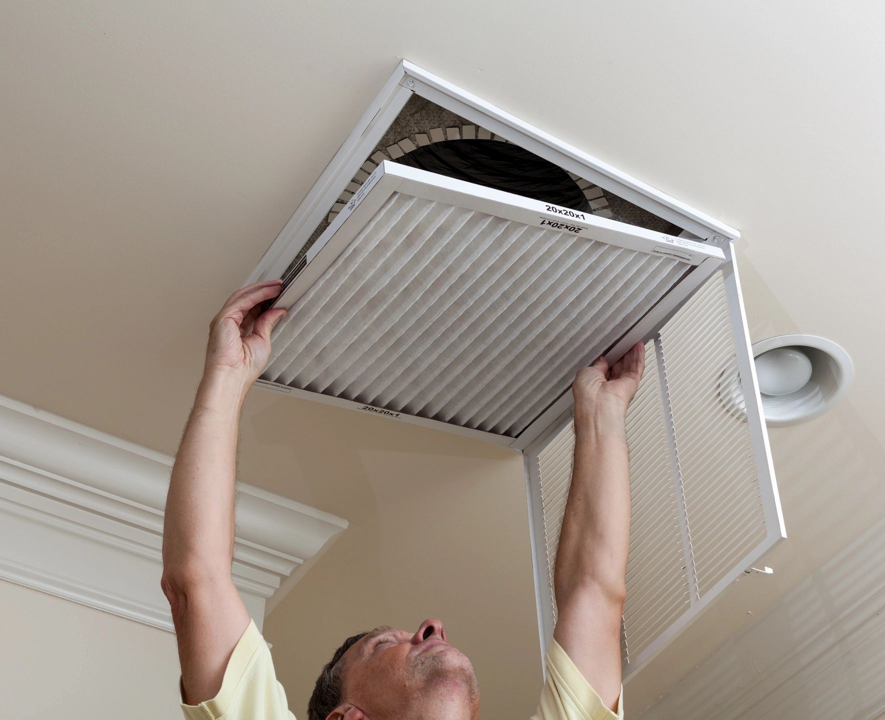 Homeowner replacing an HVAC air filter